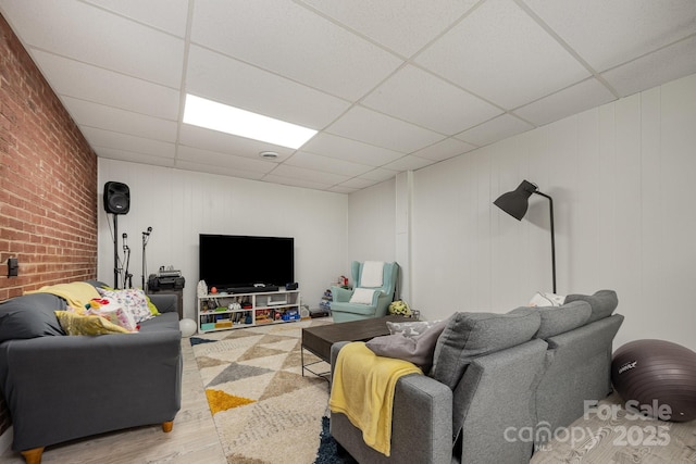 301 Rosemont Ave SE, Concord, NC 28025 - living room featuring a paneled ceiling, wood finished floors, and brick wall