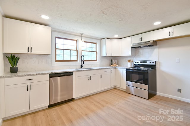 80 Sumner Ave NW, Concord, NC 28027 - kitchen with stainless steel appliances, under cabinet range hood, light wood-style floors, white cabinetry, and backsplash