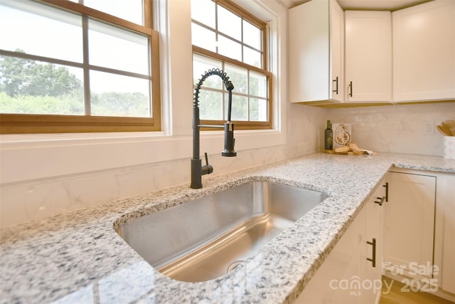 80 Sumner Ave NW, Concord, NC 28027 - kitchen view of decorative backsplash, light stone counters, and white cabinetry