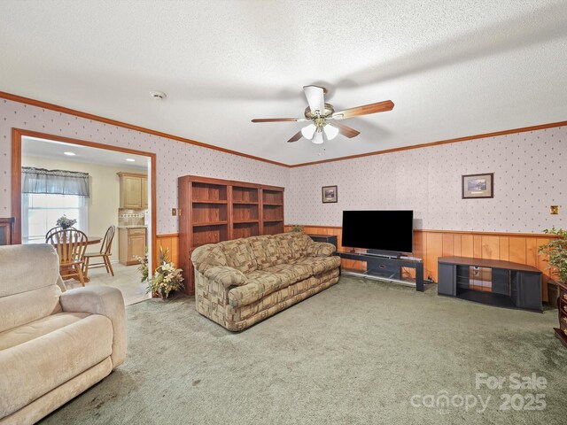 1302 Hawthorne Rd, Lancaster, SC 29720 - carpeted living area featuring crown molding, wainscoting, ceiling fan, wood walls, and a textured ceiling