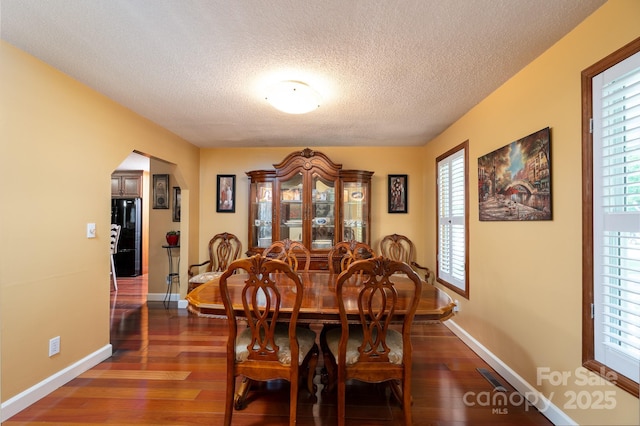 135 Primrose Dr, Salisbury, NC 28147 - dining room with a textured ceiling, dark wood-style flooring, arched walkways, and plenty of natural light