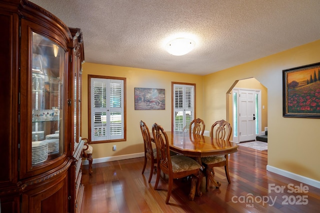 135 Primrose Dr, Salisbury, NC 28147 - dining room featuring arched walkways, dark wood-type flooring, a textured ceiling, and stairs