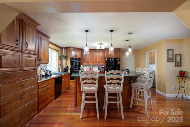 135 Primrose Dr, Salisbury, NC 28147 - kitchen with black appliances, brown cabinetry, wood finished floors, a breakfast bar, and tasteful backsplash