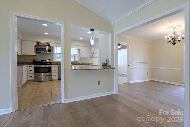 8829 Gelligum Dr, Charlotte, NC 28277 - kitchen featuring stainless steel appliances, crown molding, light wood-style flooring, vaulted ceiling, and white cabinets