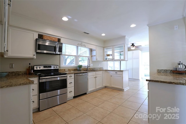 8829 Gelligum Dr, Charlotte, NC 28277 - kitchen featuring appliances with stainless steel finishes, ornamental molding, white cabinetry, light tile patterned floors, and a ceiling fan