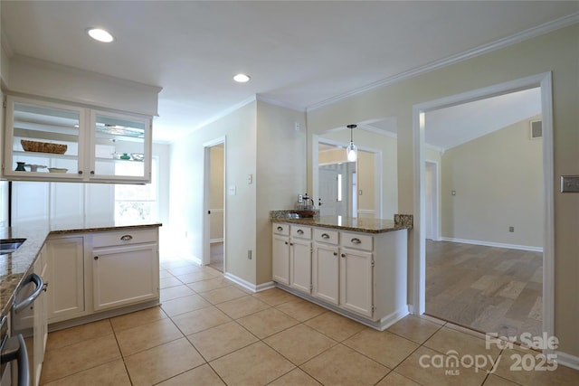 8829 Gelligum Dr, Charlotte, NC 28277 - kitchen featuring white cabinetry, light tile patterned floors, stone countertops, crown molding, and recessed lighting