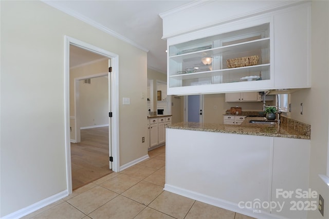 8829 Gelligum Dr, Charlotte, NC 28277 - kitchen with crown molding, stone counters, open shelves, light tile patterned floors, and white cabinetry