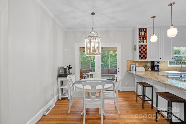2358 Sparrow Dr, Rock Hill, SC 29732 - dining area with light wood-style flooring, a chandelier, and ornamental molding