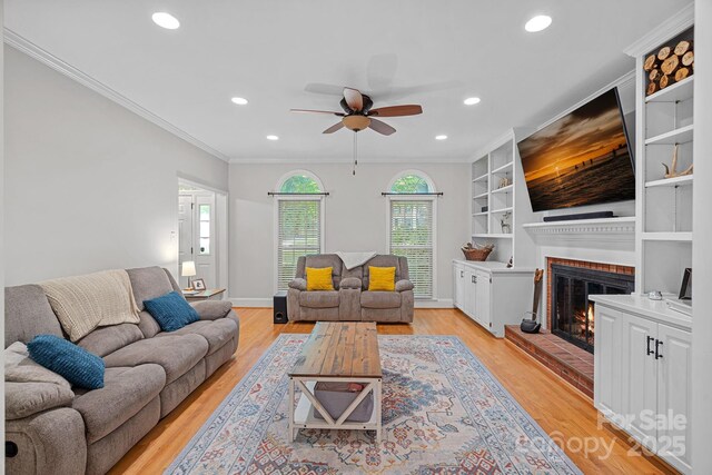 2358 Sparrow Dr, Rock Hill, SC 29732 - living room featuring a ceiling fan, a brick fireplace, recessed lighting, crown molding, and light wood-type flooring