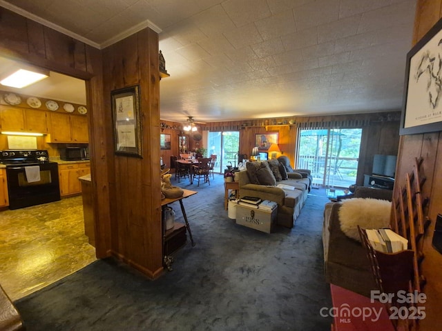 217 Shortoff Ln, Highlands, NC 28741 - carpeted living room featuring wood walls, ornamental molding, and ceiling fan
