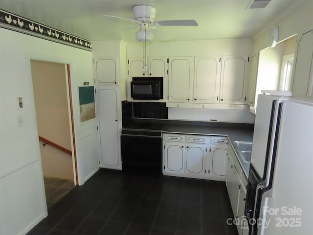 5823 Rupert Ln, Charlotte, NC 28215 - kitchen featuring freestanding refrigerator, black microwave, white cabinetry, and a ceiling fan