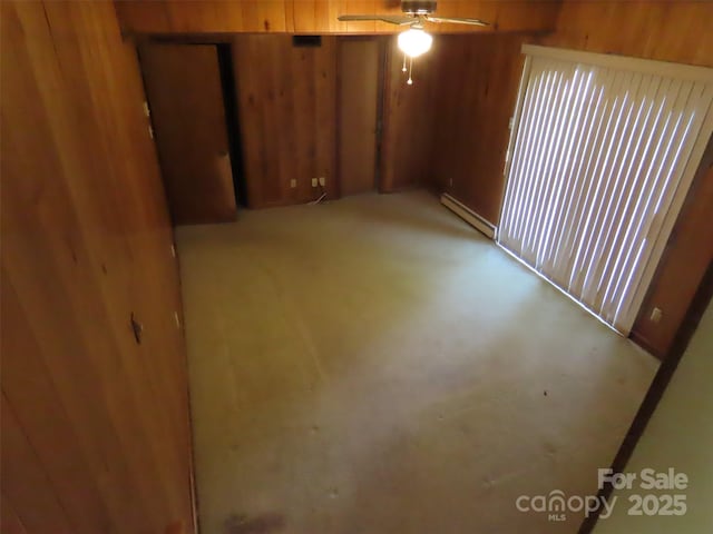 5823 Rupert Ln, Charlotte, NC 28215 - empty room featuring a baseboard heating unit, wooden walls, and a ceiling fan