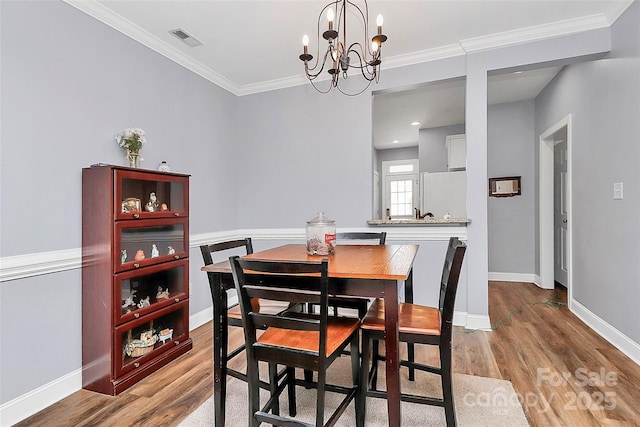 2044 Gable Way Ln, Matthews, NC 28104 - dining space featuring a chandelier, light wood finished floors, and ornamental molding