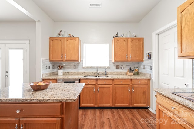 8618 Redding Glen Ave, Charlotte, NC 28216 - kitchen featuring light wood-type flooring, tasteful backsplash, light stone countertops, and dishwasher