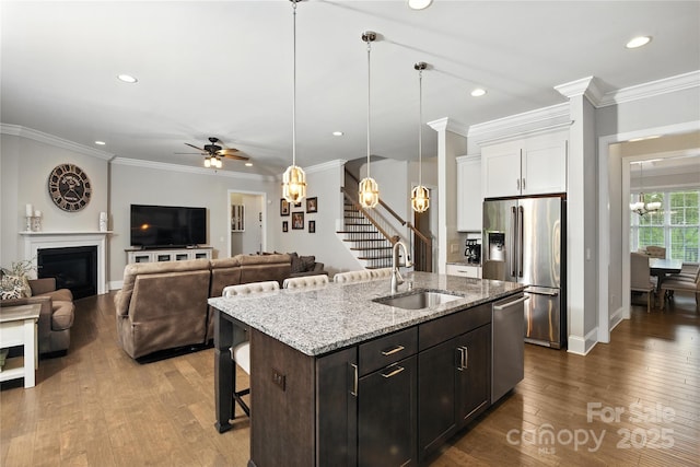 221 N Centurion Ln, Mount Holly, NC 28120 - kitchen with appliances with stainless steel finishes, a chandelier, dark wood-style flooring, a kitchen bar, and white cabinetry