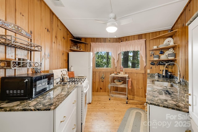 203 Laurel Ln, Little Switzerland, NC 28752 - kitchen featuring open shelves, wood walls, white appliances, light wood-type flooring, and white cabinetry
