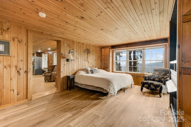 203 Laurel Ln, Little Switzerland, NC 28752 - bedroom with wooden ceiling, wooden walls, light wood-style floors, freestanding refrigerator, and a water view