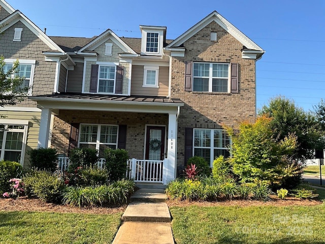 11608 Founders Park Ln, Pineville, NC 28134 - view of front of property featuring covered porch, brick siding, a standing seam roof, and a front lawn