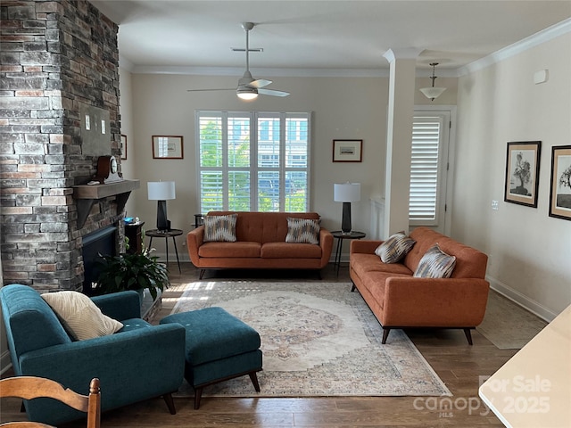 11608 Founders Park Ln, Pineville, NC 28134 - living room featuring wood finished floors, ornamental molding, ceiling fan, and a stone fireplace