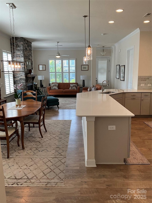 11608 Founders Park Ln, Pineville, NC 28134 - kitchen featuring ceiling fan, light wood-style flooring, crown molding, recessed lighting, and pendant lighting