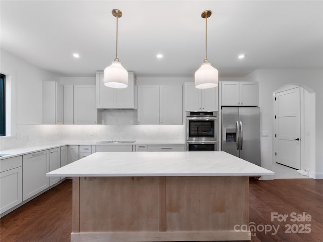 285 Poplar Crest Dr, Pisgah Forest, NC 28768 - kitchen with appliances with stainless steel finishes, a center island, backsplash, light stone countertops, and dark wood finished floors