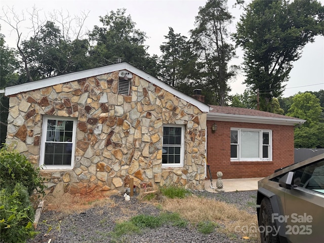 3166 Poplar Tent Rd, Concord, NC 28027 - view of home's exterior with stone siding, a chimney, and brick siding