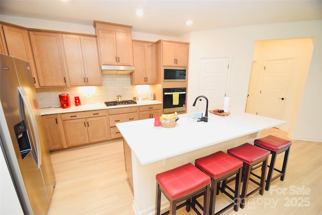 12209 Riceland Way, Midland, NC 28107 - kitchen featuring stainless steel appliances, light wood finished floors, a kitchen breakfast bar, backsplash, and light countertops