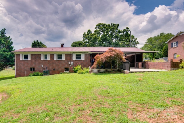 2310 Honeysuckle Pl, Lenoir, NC 28645 - rear view of house featuring a metal roof, a yard, a chimney, and brick siding