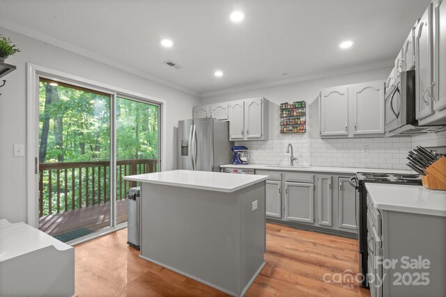 9214 Arbourgate Meadows Ln, Charlotte, NC 28277 - kitchen with stainless steel appliances, crown molding, light countertops, a kitchen island, and backsplash