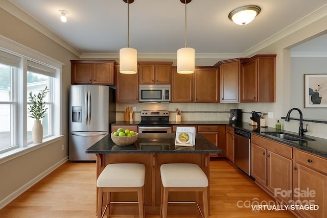 365 Battery Cir, Clover, SC 29710 - kitchen with stainless steel appliances, brown cabinetry, a kitchen island, a breakfast bar area, and light wood-style floors