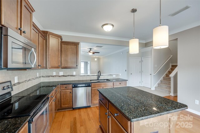365 Battery Cir, Clover, SC 29710 - kitchen featuring stainless steel appliances, brown cabinets, ornamental molding, light wood-style floors, and ceiling fan