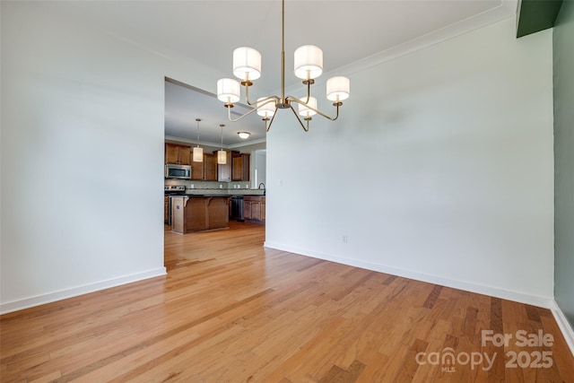 365 Battery Cir, Clover, SC 29710 - unfurnished living room featuring a chandelier, light wood-style flooring, and crown molding