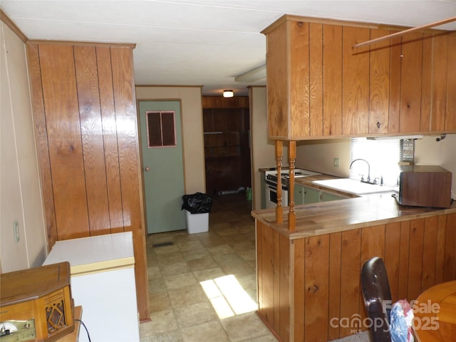 1475 Ferguson Dr, Clemmons, NC 27012 - kitchen with white stove, brown cabinets, light floors, a peninsula, and light countertops