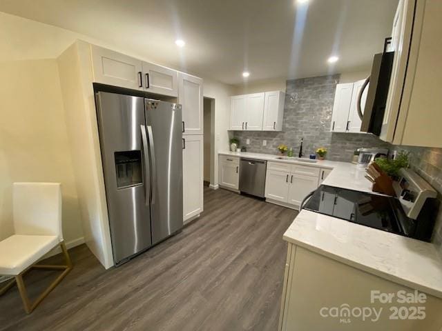 9800 Feldbank Dr, Charlotte, NC 28216 - kitchen featuring appliances with stainless steel finishes, dark wood-type flooring, tasteful backsplash, recessed lighting, and light countertops
