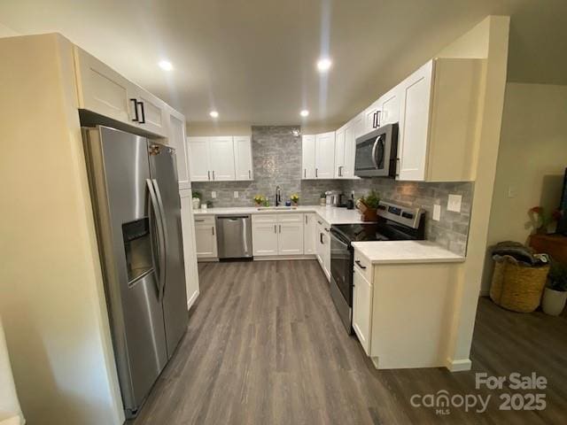 9800 Feldbank Dr, Charlotte, NC 28216 - kitchen featuring stainless steel appliances, dark wood-type flooring, decorative backsplash, light countertops, and white cabinets