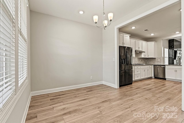 7315 Surprise Ct, Charlotte, NC 28215 - kitchen with black appliances, light wood-type flooring, a chandelier, decorative backsplash, and recessed lighting