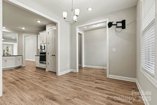 7315 Surprise Ct, Charlotte, NC 28215 - unfurnished dining area with light wood-type flooring, a chandelier, and recessed lighting