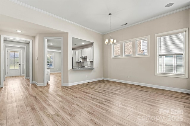 7315 Surprise Ct, Charlotte, NC 28215 - spare room with a chandelier, light wood finished floors, and ornamental molding