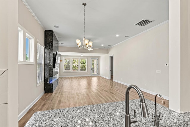 7315 Surprise Ct, Charlotte, NC 28215 - unfurnished living room featuring crown molding, a chandelier, wood finished floors, a fireplace, and recessed lighting