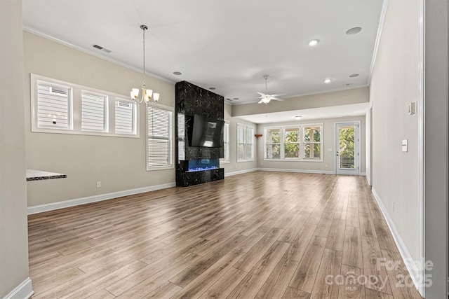 7315 Surprise Ct, Charlotte, NC 28215 - unfurnished living room with crown molding, a premium fireplace, light wood-type flooring, a ceiling fan, and a chandelier