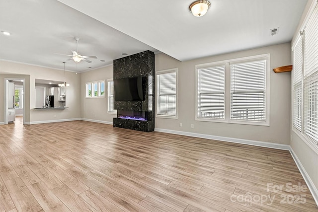 7315 Surprise Ct, Charlotte, NC 28215 - unfurnished living room featuring a ceiling fan, light wood-style flooring, and a large fireplace