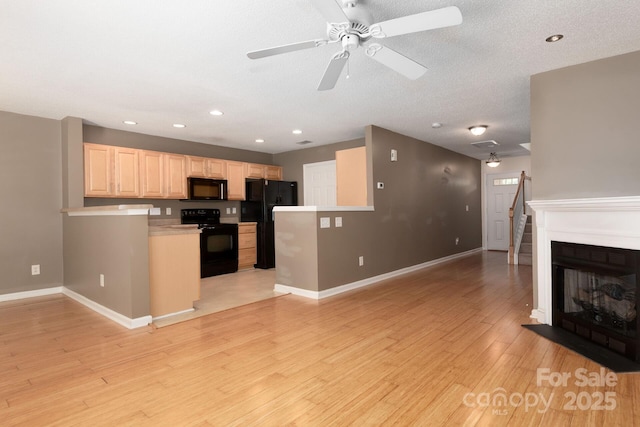 10613 Prairie Ridge Ln, Charlotte, NC 28213 - kitchen featuring black appliances, light brown cabinets, open floor plan, light countertops, and ceiling fan