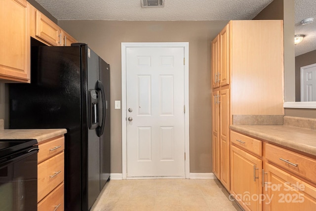 10613 Prairie Ridge Ln, Charlotte, NC 28213 - kitchen featuring a textured ceiling, black appliances, light brown cabinetry, and light countertops