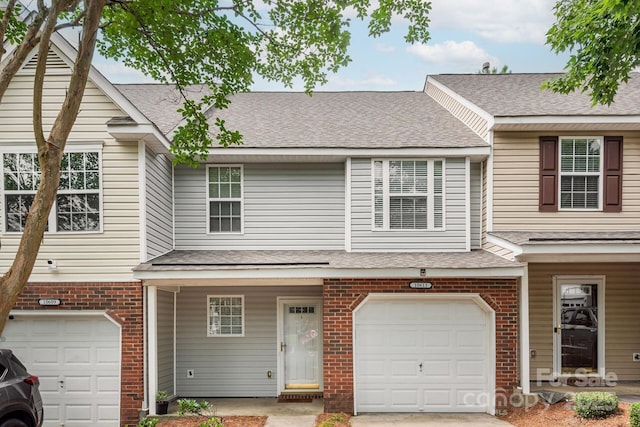 10613 Prairie Ridge Ln, Charlotte, NC 28213 - view of property with an attached garage, brick siding, a shingled roof, and concrete driveway