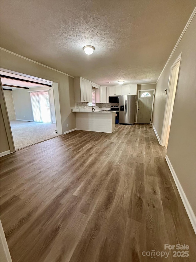 206 College Ave, Shelby, NC 28152 - kitchen with stainless steel appliances, white cabinetry, a textured ceiling, wood finished floors, and a peninsula