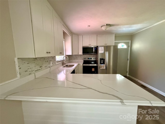 206 College Ave, Shelby, NC 28152 - kitchen featuring stainless steel appliances, a peninsula, tasteful backsplash, light stone counters, and white cabinetry