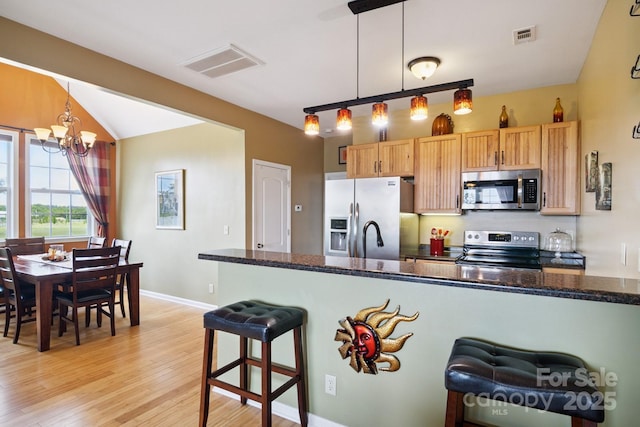 585 Clearwater Lake Rd, Kershaw, SC 29067 - kitchen with stainless steel appliances, light wood finished floors, a chandelier, and decorative light fixtures