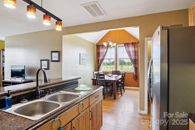 585 Clearwater Lake Rd, Kershaw, SC 29067 - kitchen featuring freestanding refrigerator, dark countertops, light wood-type flooring, a chandelier, and hanging light fixtures