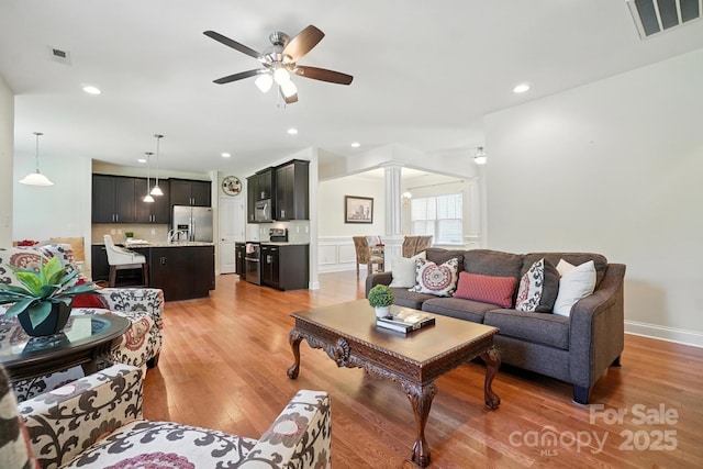8275 Normandy Rd, Denver, NC 28037 - living room featuring ornate columns, light wood-style flooring, a ceiling fan, recessed lighting, and wainscoting