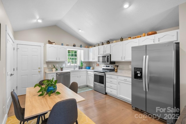 12 Buckshot Ridge Dr, Asheville, NC 28804 - kitchen with appliances with stainless steel finishes, white cabinetry, light wood-type flooring, light countertops, and lofted ceiling